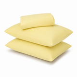 Three light yellow pillows, including two flat square pillows and one rolled pillowcase, stacked on a white background.
