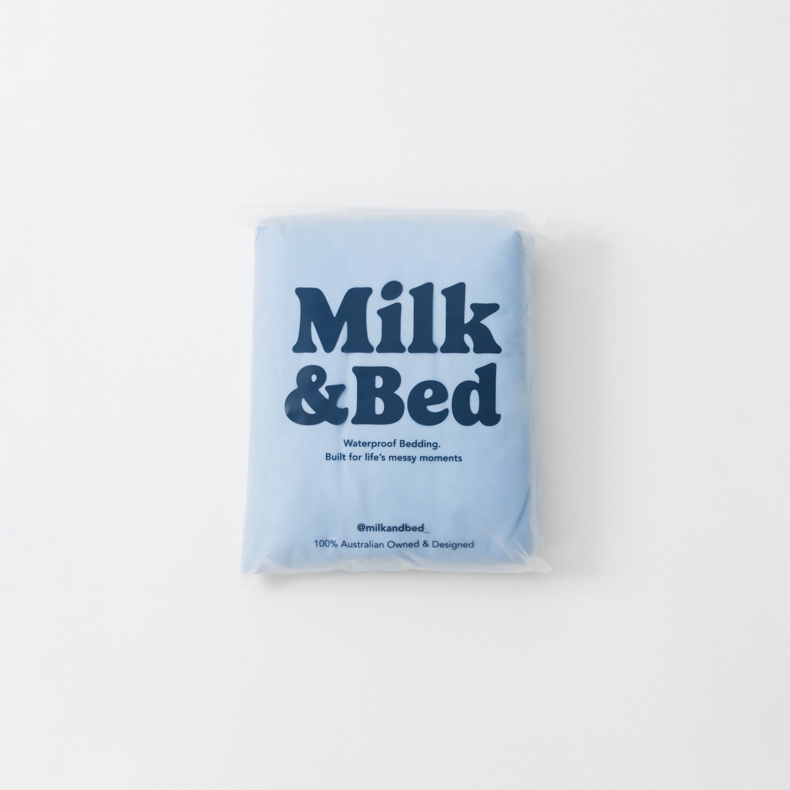 Blue package of Milk & Bed waterproof bedding on a white background