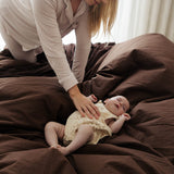Woman interacting with a baby on a bed