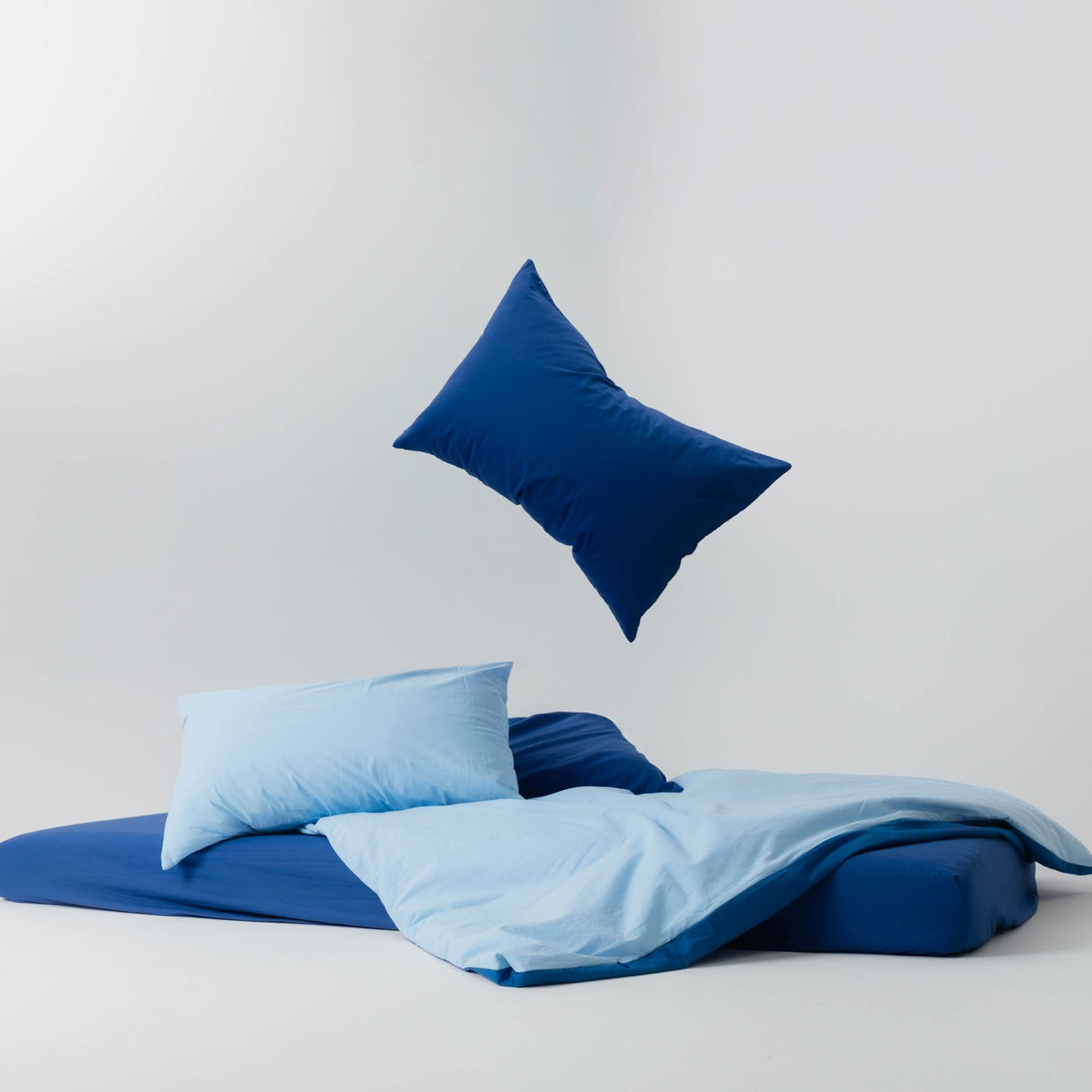 Blue bedding set with pillows on a light gray background